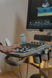 Clinician using an echocardiography ultrasound machine during a heart assessment